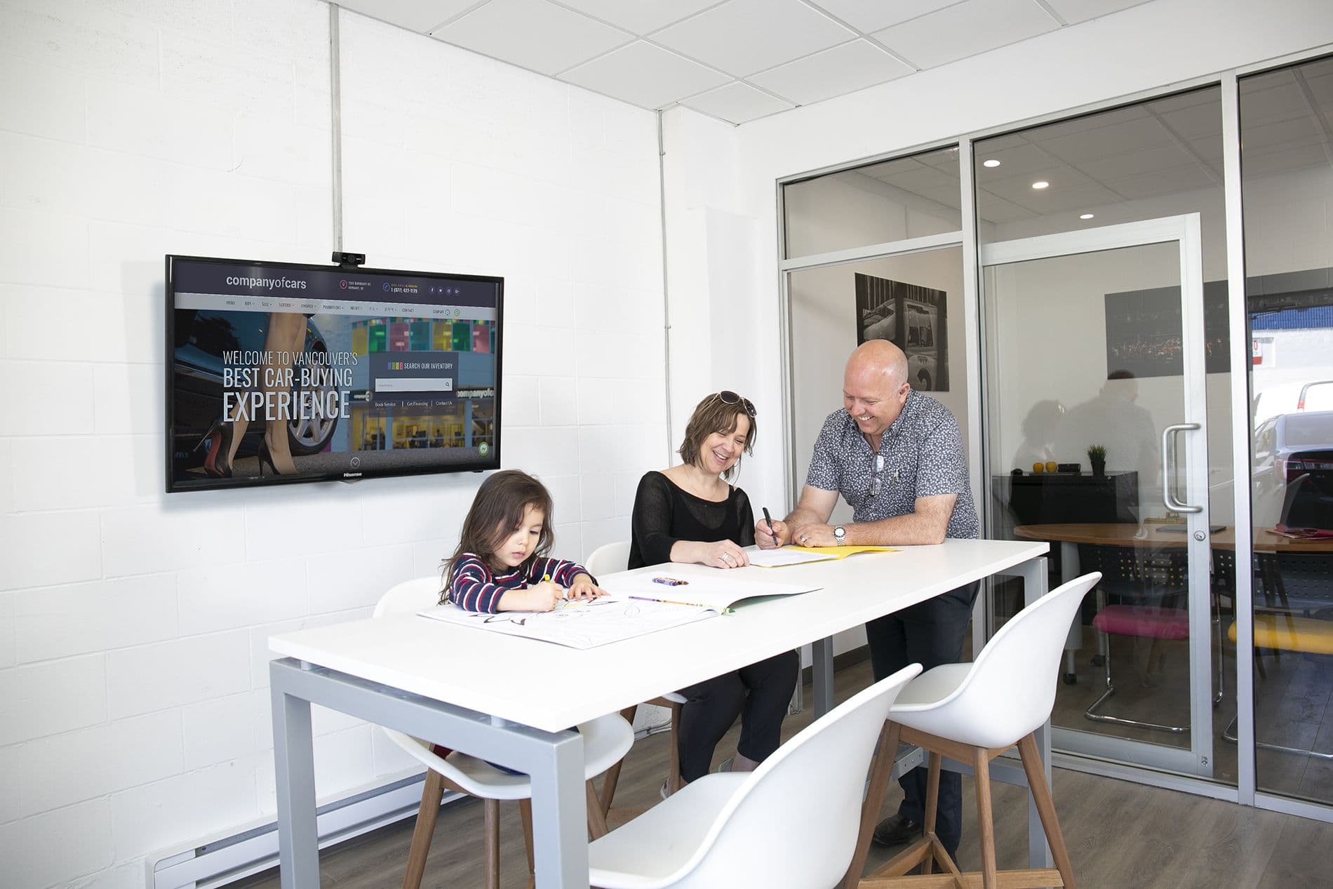 A family reviewing and signing financing paperwork together at a table